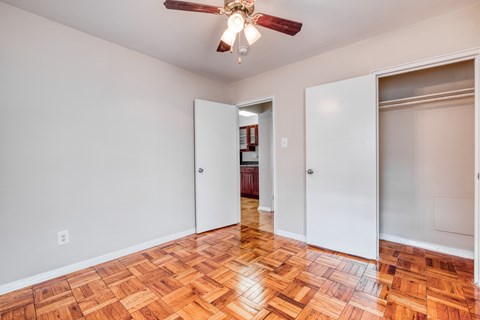 an empty living room with wood flooring and a ceiling fan